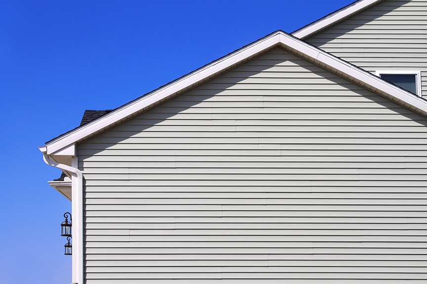 New home with gray vinyl siding and blue sky in the background - Decatur, IL